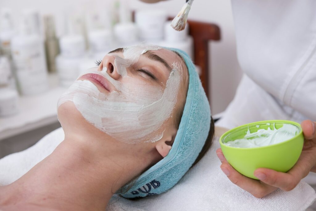Donna con maschera viso idratante e fascia turchese
